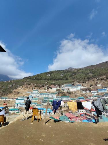 a man walking on the beach with a group of houses at Hill-Ten in Namche