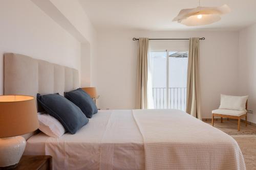a bedroom with a large white bed with blue pillows at New! Villa Lina in Santa Gertrudis de Fruitera