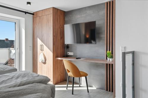 Mühlenloft في كاروليننسيل: غرفة نوم بها مكتب وكرسي وسرير