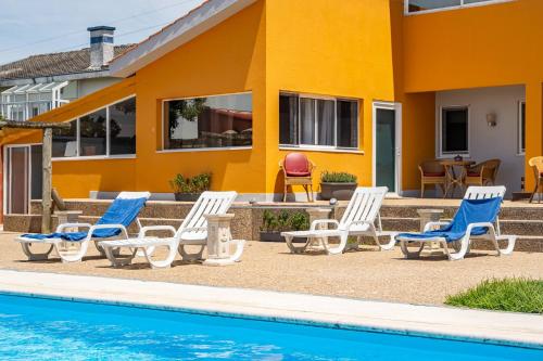 a group of chairs and a pool in front of a house at Wake up with the Sea Breeze- House with pool AP3 in Lavra
