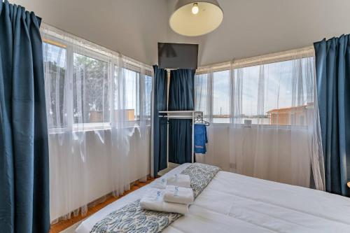 a bedroom with a bed and two large windows at Wake up with the Sea Breeze- House with pool AP3 in Lavra