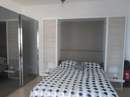 a bedroom with a bed with a blue and white comforter at piedameretnature in Lagord
