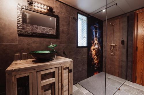 a bathroom with a sink and a glass shower at La Baguette du Sorcier - Logement insolite immersif jusque 4 personnes entre Liège & Maastricht in Visé