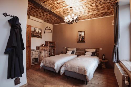 a bedroom with two beds and a wooden ceiling at La Baguette du Sorcier - Logement insolite immersif jusque 4 personnes entre Liège & Maastricht in Visé