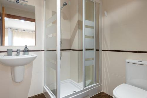 a bathroom with a shower and a sink and a toilet at Les nid doré suites in Roses