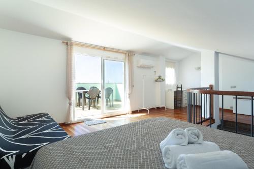 a bedroom with a bed and a large window at Les nid doré suites in Roses