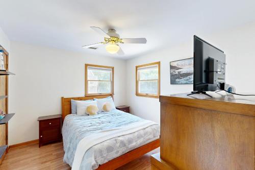 a bedroom with a bed and a flat screen tv at Worries not Found in Kill Devil Hills