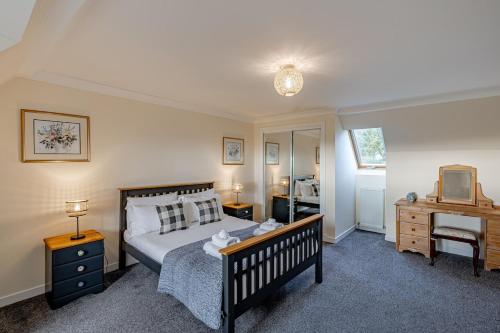 a bedroom with a bed and a desk and a television at Ballo Cottage - Stunning views in Leslie