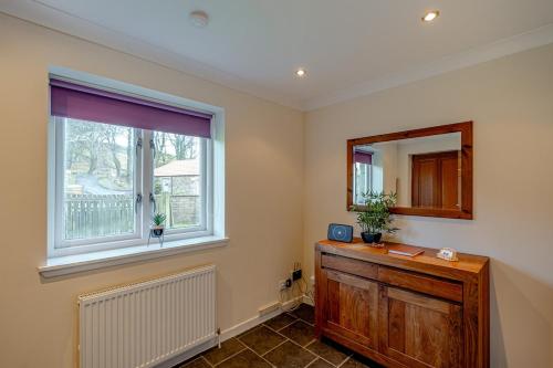 a room with a window and a wooden dresser at Ballo Cottage - Stunning views in Leslie