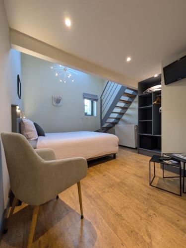 a bedroom with a large bed and a staircase at La Vieille Forge B&B in Houffalize