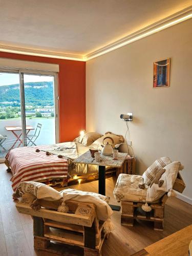 a room with two beds and a table and a window at Studio cosy - Porte de Genève & Voie Verte in Ambilly