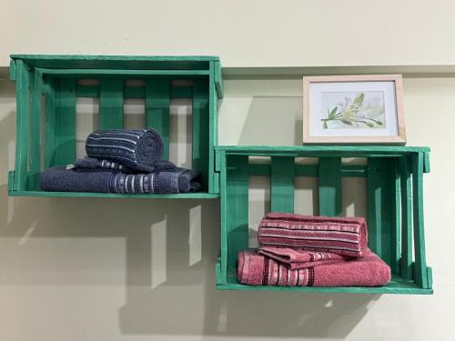 two green shelves with towels on a wall at Gode Wind in Eckernförde
