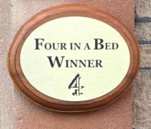 a sign that says four in a bed winner on a wall at Brooklands 5 Star Guest House in Penrith