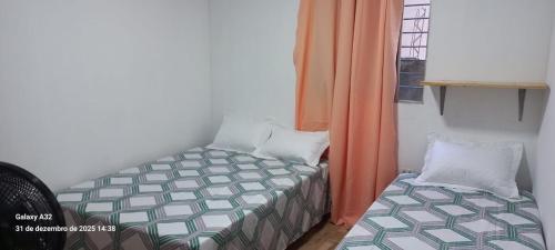 a small bedroom with a bed and a window at Aconchego das Araras in Sirinhaém