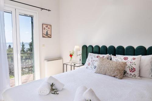 a bedroom with a large white bed with a green headboard at The 7 Trees Apartments by Konnect, Nisaki in Nisaki