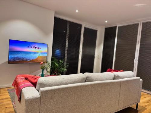 a living room with a couch and a flat screen tv at Top Apartment in Kranenburg - central & quiet - terrace and large windows - incl parking, fast WiFi, Box-Spring bed, washer & dryer, Netflix in Kranenburg