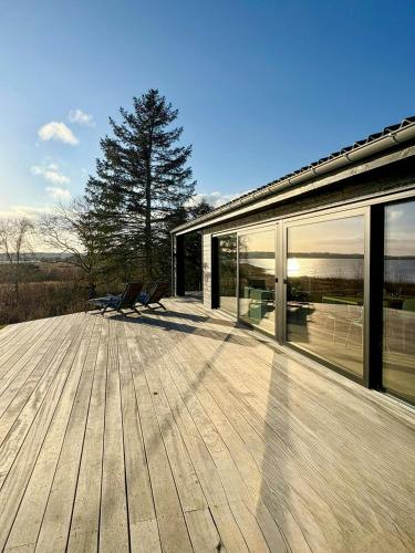 a wooden deck with chairs on top of a house at Idyllic Modern House Overlooking Lammefjord in Vig