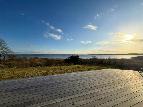 a wooden deck with a view of the water at Idyllic Modern House Overlooking Lammefjord in Vig