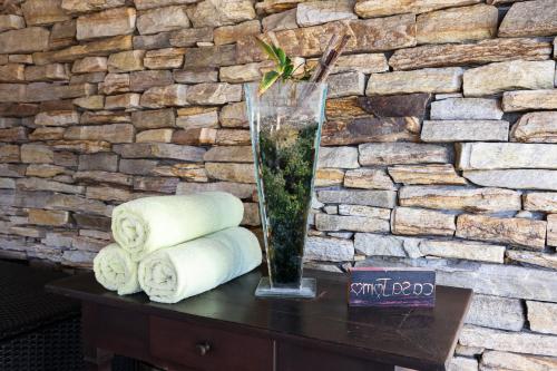a vase on a table with towels in a room at casaJOMO in Rio de Janeiro
