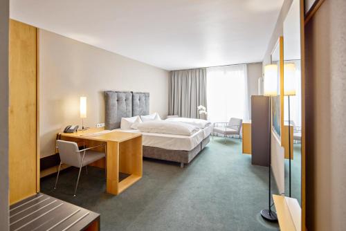 a hotel room with a bed and a desk at Hotel an der Stadtmauer in Schorndorf