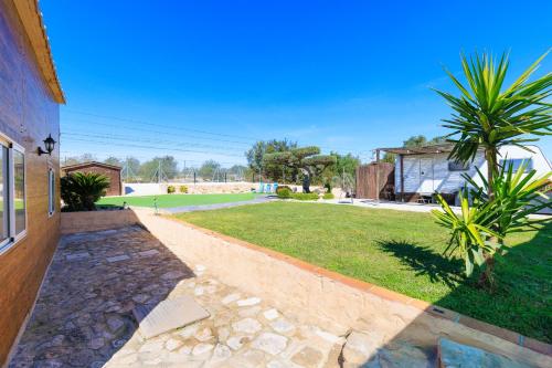 a house with a walkway next to a yard at Hauzify I Mas Blau in L'Ametlla de Mar