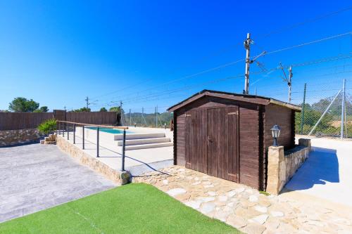 a small wooden out house in a yard at Hauzify I Mas Blau in L'Ametlla de Mar