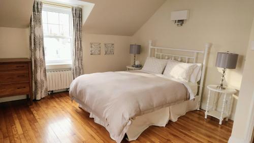 a bedroom with a white bed and a window at Gîte La Belle Aventure B&B in Shawinigan