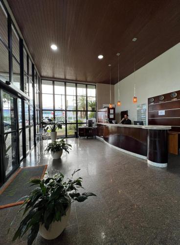 a large lobby with potted plants in a building at Brisamar Suite Hotel in Florianópolis