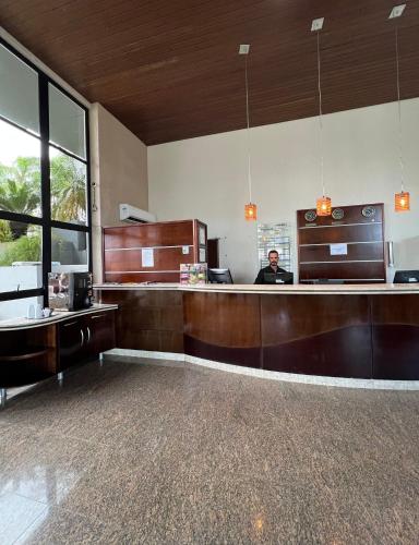 a man is sitting at a counter in a restaurant at Brisamar Suite Hotel in Florianópolis
