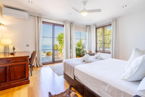 a bedroom with a bed and a desk and windows at Sa Torre Voramar in Sa Torre
