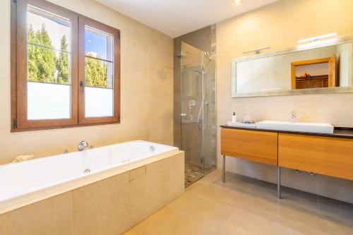 a bathroom with a tub and a sink and a mirror at Sa Torre Voramar in Sa Torre