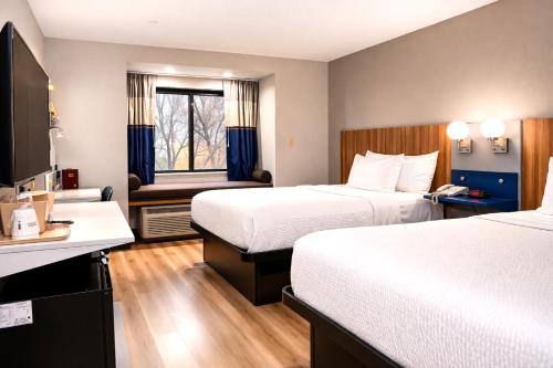 a hotel room with two beds and a desk at Microtel Inn by Wyndham - Murfreesboro in Murfreesboro