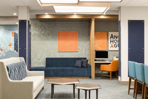 a living room with a blue couch and chairs at Holiday Inn Express & Suites Anchorage - Midtown in Anchorage