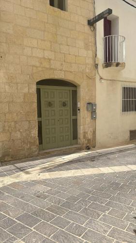 a stone building with a green door on a street at rabat apartment in Rabat