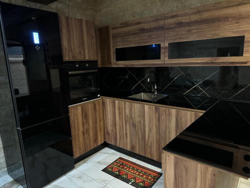 a kitchen with wooden cabinets and a black counter top at rabat apartment in Rabat