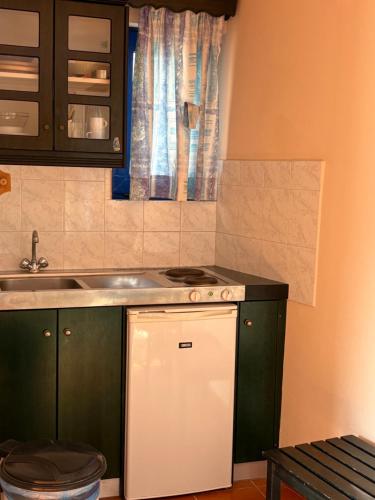 a kitchen with a sink and a stove top oven at Bay Watch in Karpathos