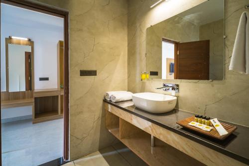 a bathroom with a sink and a mirror at Tripli Hotels Solune in Rishīkesh