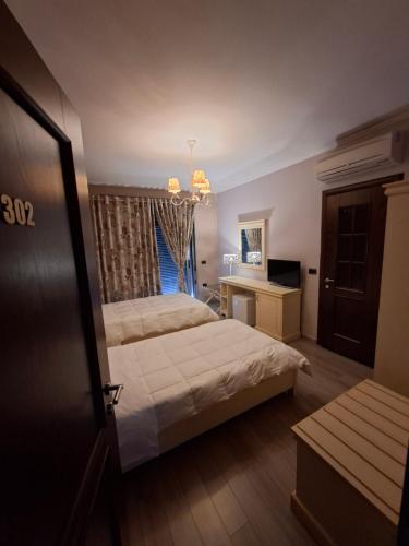 a bedroom with a bed and a desk and a window at Dreams Hotel in Gjirokastër