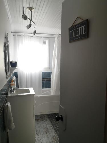 a bathroom with a tub and a sink and a window at Auberge de la rive de Charlevoix - Auberge familiale pour voyageurs de tous âges in Saint-Joseph-de-la-Rive