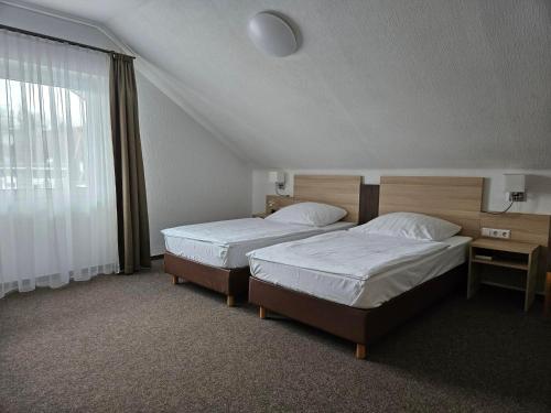 a hotel room with two beds and a window at Hotel Zum Holländer in Lindlar