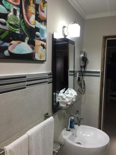 a bathroom with a sink and a mirror at Malika Apartments in Westpunt