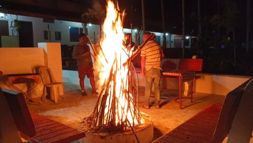 a group of people standing around a fire pit at Bougainvillea in Chikmagalūr