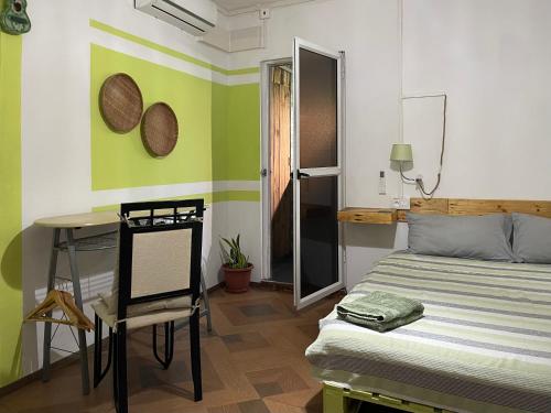 a bedroom with a bed and a table and a chair at Kowlessur Residence in Surinam
