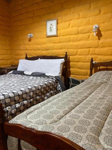 two beds sitting next to each other in a room at Luna Huasi Posada in Maimará