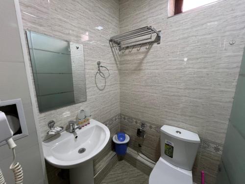 a bathroom with a sink and a toilet and a mirror at Al Samarqandi Hotel in Samarkand