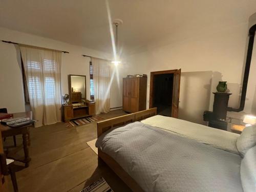 a bedroom with a bed and a room with a desk at Casa Arthur, Transylvanian heritage house in Richişu
