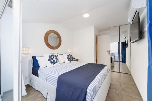 a bedroom with a large bed and a mirror at Casa Margot Old Town Rooftop Walk Promenade in Portimão