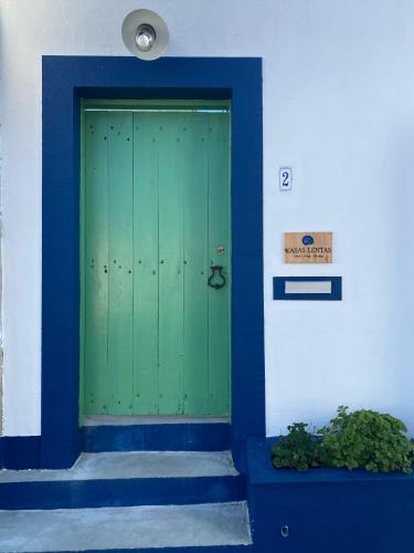 a green door on the side of a building at CASAS LENTAS Slow Living-Óbidos in Sobral
