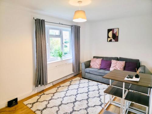 a living room with a couch and a window at 2 Bed Spacious Apartment, Sleeps 4, Free Wifi, Free Parking, Amenities Nearby, Good Transport Links Nearby, Contractors and Holidays in Harlow