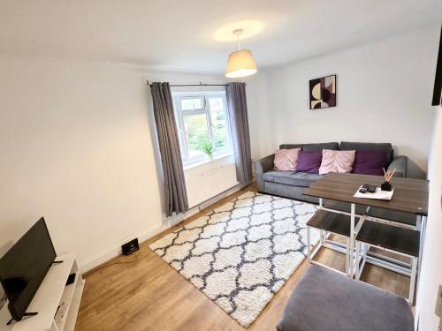 a living room with a couch and a table at 2 Bed Spacious Apartment, Sleeps 4, Free Wifi, Free Parking, Amenities Nearby, Good Transport Links Nearby, Contractors and Holidays in Harlow